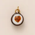 Detailed macro view of a round ceramic food-themed DIY pendant with a glossy finish and gold loop - Passion Fruit