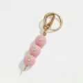 Dettaglio del ciondolo per borsa con perle rosa, strass brillanti e chiusura dorata - Oliva Rosa