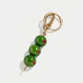 Gedetailleerde weergave van de groene olijf tasbedel met goudkleurige metalen hardware - Grasgroene Olijf
