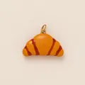 Dettaglio di un ciondolo a forma di croissant giallo con strisce rosse e anello dorato. - Ciondolo Croissant 1