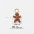Macro detail of a gingerbread man enamel charm pendant with measurement annotations - Gingerbread Man Shape