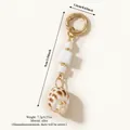 Vintage-Taschenanhänger mit weißen geometrischen Perlen und Naturmuschel-Anhänger, Goldclip. - Seeschnecken-Knoten-Stil