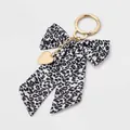Primo piano di un portachiavi con fiocco leopardato e ciondolo a cuore dorato lucido - Stile Fiocco Leopardato Cuore