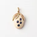 Vue macro détaillée d'un pendentif gland avec feuilles d'or et pierres bleues carrées - Pendentif Olive Gemme Bleue Septembre