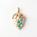 Détail macro d'un pendentif en forme de fruit doré avec turquoises et perles blanches - Pendentif Raisin Gemme Bleue Décembre