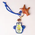 Artisanal hand-painted blue vase and star-shaped bag charm with vibrant cord and gold clasp - Blue Vase Charm
