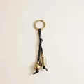 Vintage brass bell and leather cord keychain detail showing antique finish textures - Black Leather Gourd Bell Charm / Black