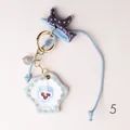 Detailed view of a hand-painted ceramic star charm with purple floral and fish motifs - Purple Flower Shell Charm