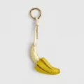 Close-up of woven leather banana keychain with vintage gold metal ring - Woven Banana Charm / Yellow