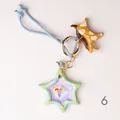 Whimsical hand-painted star and spotted dog charm bag accessory with a blue braided cord - Fruit Bowl Star Charm