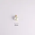 Primo piano di un ciondolo a perla bianca da 10mm con occhiello dorato per gioielli fai da te - Ciondolo Con 9 Perle Rotonde