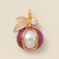 Detailed macro view of a gold-plated berry pendant with large white pearl and purple enamel - Lychee Pendant
