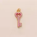 Detailed view of a pink heart-shaped key pendant with gold-toned metal edges. - Pink Heart Key Pendant Only
