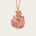 Macro view of a cute hamster emerging from a miniature pink patterned trunk pendant - Pink Suitcase Hamster Style
