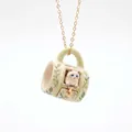 Detailed view of a miniature ceramic mug necklace with a cute white cat pendant. - Green Leaf Cat Mug Style