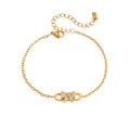 Detailansicht eines vergoldeten Titanstahl-Armbands mit kristallbesetzter Schleife - Büroklammer Schleife Armband