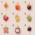 Macro view of 9 unique fruit-themed jewelry pendants with colorful enamel and pearls. - Persimmon Pendant