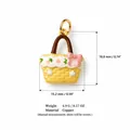 Detailed view of yellow enameled copper basket charm pendant with a pink bow decoration - Bag Shaped
