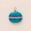 Primer plano de un colgante de macaron en esmalte azul con relleno rosa y aro dorado - Colgante Solo / Macarrón Azul