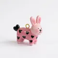 Primer plano de un colgante de conejo rosa con patrones de corazones negros y aro dorado - Colgante de Conejo con Corazón Negro Solo