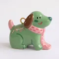 Primer plano de un colgante de perro de cerámica verde con bufanda rosa y aro dorado - Colante de Cachorro Verde con Bufanda Rosa Solo