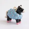 Vista detallada de un tierno colgante de oveja de cerámica negro y azul con puntos rosas - Colgante de Poni Negro con Ropa Azul Solo