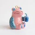 Vista detallada de un lindo colgante de oso rosa sosteniendo una taza azulada - Colgante de Oso Rosa Bebiendo Refresco Solo