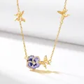 Close-up of gold butterfly and purple pansy birth flower enamel necklace - February