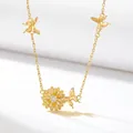 Detailed view of elegant gold-tone flower necklace with butterflies and crystal center. - November