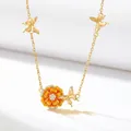 Detailed view of a gold plated copper birth flower necklace with orange enamel and butterflies. - October