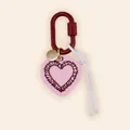 Close-up of a pink heart-shaped bag charm with a red metal carabiner and white cord - Burgundy Lace Heart Style