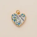 Detailed view of gold-framed heart pendant featuring a hand-painted white horse and blue flowers - Horse Heart Pendant