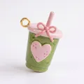 Vue macro détaillée d'une breloque en émail vert macaron et rose en forme de tasse - Style Thé au Lait Cœur / Vert menthe