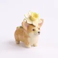 Detailed close-up of a miniature ceramic Corgi pendant with a yellow flower on its head. - Daffodil Corgi Pendant (MQPK262714KI) / Pendant Only
