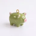 Gros plan d'un charm cochon en émail vert avec des oreilles roses pour bijoux DIY - Forme de Cochon / Vert menthe