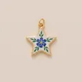 Detailed macro shot of a vintage gold star pendant featuring a painted blue flower - Blue Flower Star Pendant