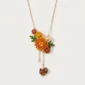 Primo piano di una collana floreale smaltata con ciondolo a nappa di tacchino - Collana Vintage Tacchino Crisantemo di Novembre