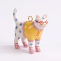 Vista dettagliata di un ciondolo a forma di gatto in ceramica dipinto a mano - Ciondolo Gatto Bianco Con Occhiali Rossi E Maglione Giallo