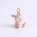 Detailansicht eines weinenden rosa Emaille-Hasenanhängers mit goldenen Akzenten - Rosa Sitzendes Kaninchen Anhänger