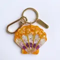 Elegante llavero de acrílico con forma de concha y un cierre de mosquetón dorado brillante - Colgante de Concha Colorida