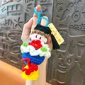 Handmade crochet graduation doll keychain featuring a mortarboard and red flower decoration - Blue Graduation Bouquet / Blue
