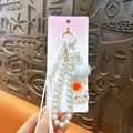 Elegante amuleto de bolso con cuentas de perlas, colgante floral y pompón blanco - Blanco