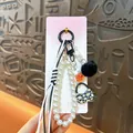 Lindo colgante para bolso con perlas blancas, dije de margarita y suave pompón negro - Negro