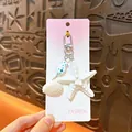 Ocean style keychain with white starfish and shell charms on a pink gradient card. - Ocean Starfish Shell Charm / White