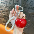Elegante portachiavi a ciliegia rossa con cinturino in perle bianche e moschettone a cuore - Mela Rossa