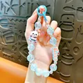 Close-up of a cute panda beaded keychain charm with iridescent beads and Kiss tag - Panda Beaded Phone Chain / Blue