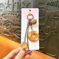 Cute Maillard style pretzel and donut keychain bag charm with fluffy brown pom-pom - Bagel / Brown