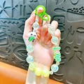Detailed view of cute panda keychain with iridescent beads and 'LOVE YOU' charm. - Panda Beaded Phone Chain / Green