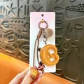 Cute pretzel bread keychain with pom-pom and football pendant on display card - Smile Pretzel Knot / Brown