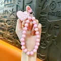 Elegant pink iridescent beaded phone strap featuring heart charm and lobster clasp - Pink